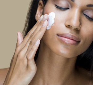 applying moisturizer black woman